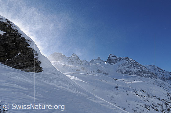 Foto: Schneeverfrachtung während Föhnsturm. Durch den stiebenden Schnee sind Albrunhorn, Bochtehorn, Kleines Schinhorn und Seewischhorn erkennbar.