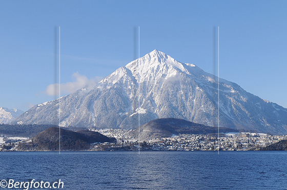 Foto: Frisch verschneite Niesenpyramide. Davor die blaue Wasserfläche des Thunersee.