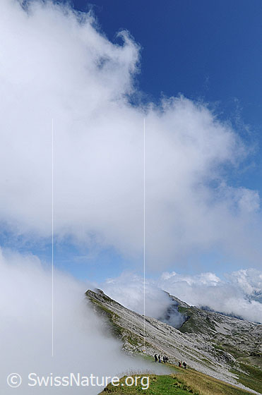 Foto: Stimmung am Grat Schrattenfluh. Stimmung mit stauenden Wolken an der Gratkante der Schrattenfluh. Auf dem Grat hält sich eine Wandergruppe auf.