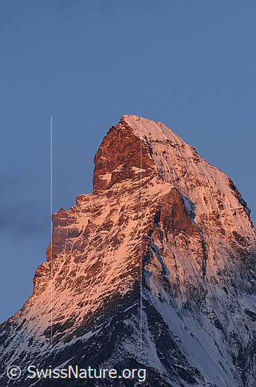 Foto: Morgenstimmung am Matterhorn. Erstes Sonnenlicht fällt auf den Charakterberg und lässt ihn rötlich erscheinen.