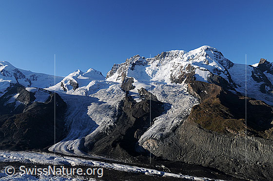 Foto: Gletscher und Viertausender in der Region Zermatt. Zu sehen sind Castor, Pollux, Breithorn, Schwärzegletscher, Breithorngletscher, Triftjigletscher und im Vordergrund die Mittelmoräne des Gornergletschers.
