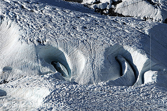 Foto: Eismasse des Gornergletschers mit Löchern, Spalten und Strukturen auf der Oberlfäche. Toll geformter supraglazialer Schmelzwasserkanal.