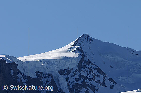 Foto: Portrait Nordend. Die Normalroute führt von rechts vom Silbersattel über den Südgrat (S-Grat) zum Nordend.
In der Fallinie des Gipfels ist der Westsporn (W-Sporn, sog. Morshead-Sporn) zu sehen, über welchen eine schwierige Route zum Gipfel führt.