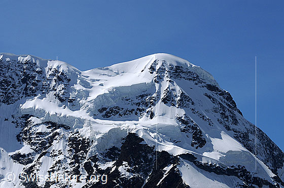 Foto: Breithorn (Zermatt). In der Fallinie des Gipfels verläuft der sog. Triftjigrat. In der Bildmitte ist das Triftjiplateau (Gletscherplateau) zu sehen.