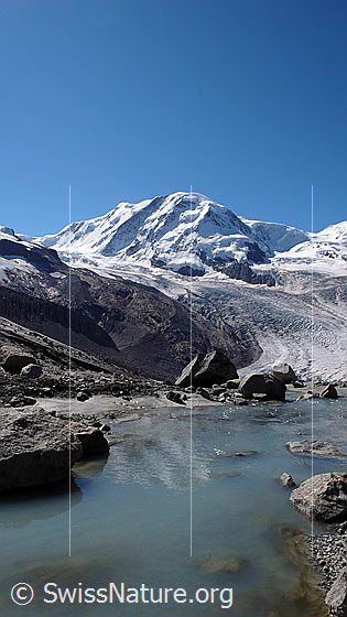 Foto: Gletscherbach am Rand des Gornergletschers. Im Hintergrund sind der Liskamm und der Grenzgletscher zu sehen.