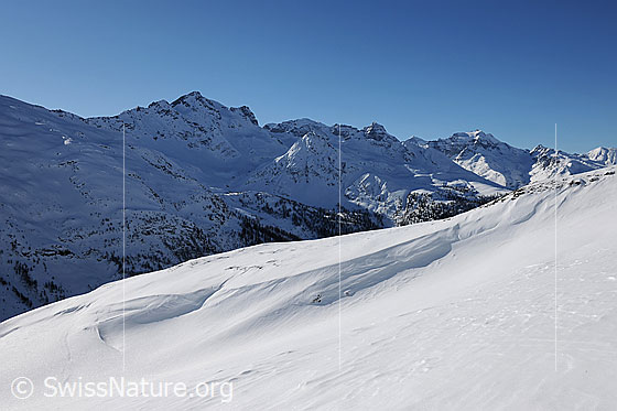 Foto: Berglandschaft mit Licht und Schatten. Blick über eine Wächte in die Nordhänge von Schwarzhorn, Scherbadung, Helsenhorn und Hillehorn.