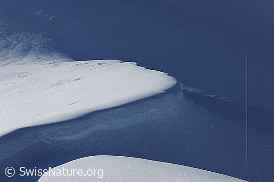 Foto: Lichtspiel und Formen im Schnee. Wechte mit Licht und Schatten.