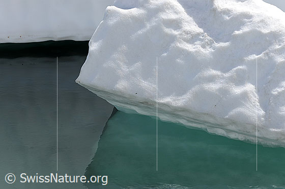 Foto: Formen und Muster in Wasser, Eis und Schnee. Datailansicht einer Eisscholle, welche sich im Wasser spiegelt.