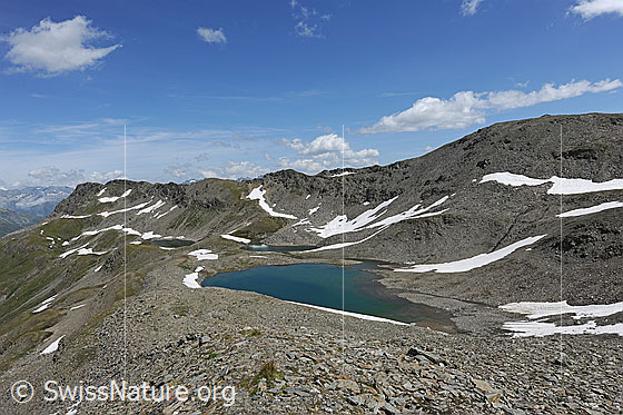 Foto: Stotzigen Firsten mit den drei Schwärziseeli. Die Bergseen sind umgeben von steinigem Gelände mit Schneeresten. Über der Berglandschaft sind kleine Quellwollken zu sehen.