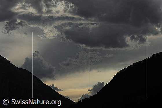 Foto: Bedrohliche, dunkle Wolken über einem Taleinschnitt.