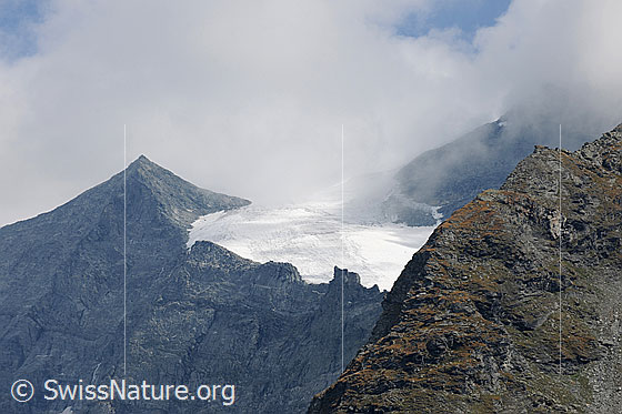 Foto: Homattugletscher mit Wolkenstimmung. Wolkenfetzen ziehen über Felsgrate und den Gletscher.
