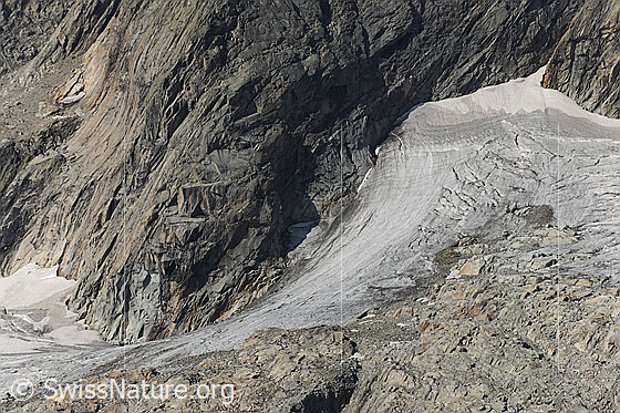 Foto: Gletscher und Fels. Dünne Eisschicht am Gletscherrand des Gruebengletschers.