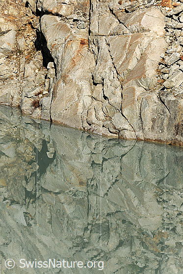 Foto: Formen im Fels mit Spiegelung im Bergsee.