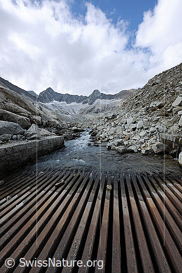 Foto: Wasserfassung im Hochgebirge. Das Wasser eines Bergbachs wird zur Energiegewinnung genutzt.