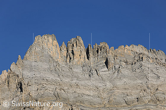 Foto: Felstürme am Südgrat des Doldenhorn. Blick von Süden in die strukturierte Felswand mit Felsbändern aus unterschiedlichem Gestein.