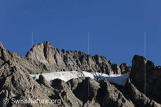 Foto: Gletscher in der Südflanke des Doldenhorn. Der Gletscherrest erstreckt sich über eine Terrasse und ist von Felsformationen umgeben.
Gletscher: Doldenhorn-SE