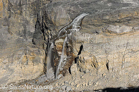 Foto: Wasserfall im Vorfeld des Kanderfirns (Alpetligletscher). Das Wasser fällt über eine Felsstufe aus Dolomit (ev. Rötidolomit), welche interessante Strukturen aufweist.