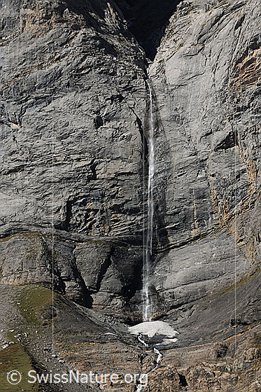 Foto: Feiner Wasserfall im Gasteretal. Ein Wasserstrahl fällt über eine Felswand in eine Mulde.