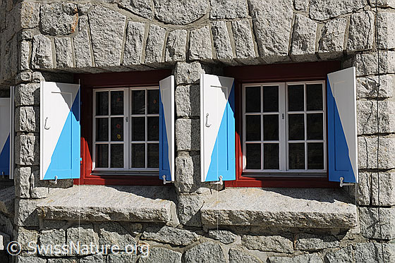 Foto: Fenster der Bächlitalhütte. Steinmauer und Fenster mit frisch gestrichenen Fensterläden.