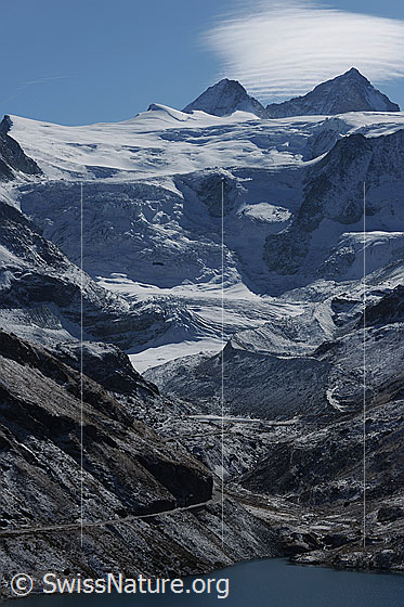 Foto: Lac de Moiry, Glacier de Moiry, Grand Cornier und Dent Blanche mit Föhnwolke. Gletscher und Berglandschaft sind leicht verschneit.