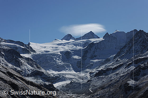 Foto: Grand Cornier, Dent Blanche und Pointe de Mourti und die Gletscherlandschaft des Glacier de Moiry im Herbst. Am blauen Himmel hat sich eine kleine Linsenwolke gebildet.