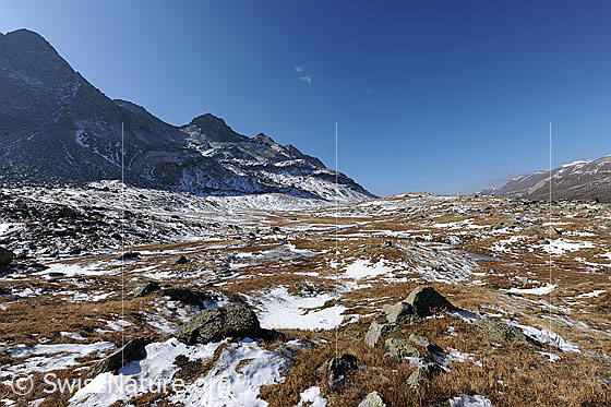 Foto: Die Weite einer Hochebene im Herbst. Erster Schnee liegt zwischen den kleinen Felsblöcken im dürren Gras.