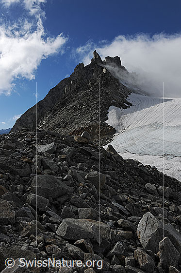 Foto: Poncione di Cassina Baggio mit Wolkenstimmung und viel Geröll am Rand des Chüebodengletschers.