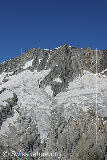 Foto: Dammastock, Schneestock und Rotfirn. Die Zunge des Gletschers ist abgeflacht und zieht sich über die steilen Felsen zurück.