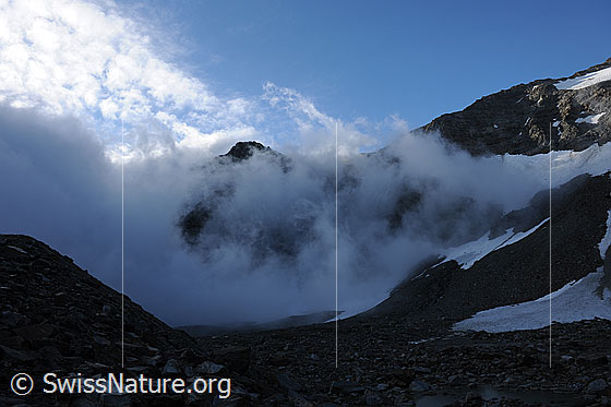 Foto: Wolkenstimmung und Morgenlicht am Sirwoltesee. Die Geröllhänge und Schneefelder liegen noch im Schatten.