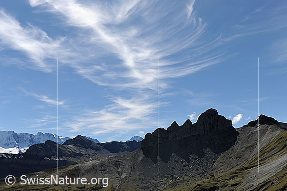 Foto: Bietenhorn und Lobhörner. Die Felszacken der Lobhörner spiegeln sich als Schattenwurf in den Geröllhängen. Federwolken zieren den blauen Himmel über der Jungfrauregion.
