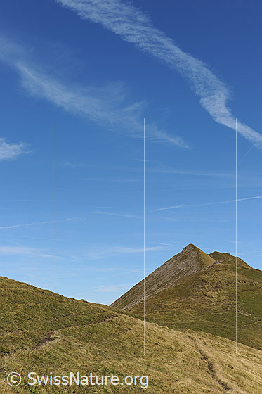 Foto: Grat mit Bergweg an der Sulegg. Die Alpweiden sind bereits herbstlich gefärbt. Am Himmel sind Kondensationsstreifen zu sehen.