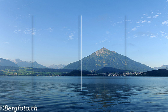 Foto: Thunerseee und Niesen. Blick über die leicht gewellte und leicht spiegelnde Wasserfläche zur Bergpyramide des Niesen.