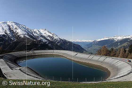 Foto: Ausgleichsbecken eines Wasserkraftwerks in Walliser Berglandschaft.