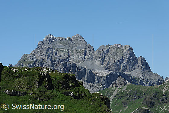 Foto: Schächentaler Windgällen.
Markantes Felsmassiv mit grünem Bergrücken im Vordergrund.