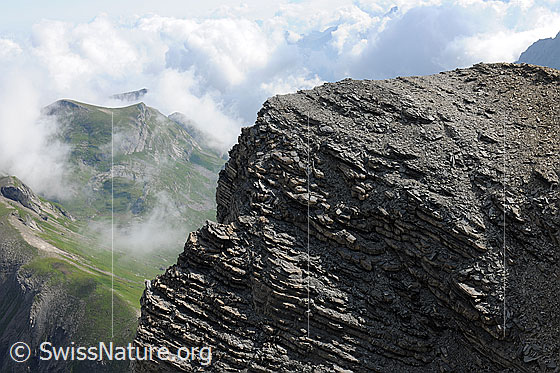Foto: Schichtungen am Gipfel der Chilchflue (loses Gestein). Der Grat im Hintergrund verliert sich in der brodelnden Quellbewölkung.