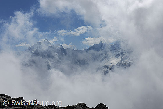 Foto: Wolkenstimmung um Jungfrau und Gletscherhorn. Wolkenfetzen der aufziehenden Quellbewölkung reissen auf und hüllen die Berglandschaft kurze Zeit später wieder in einen Wolken- und Nebelschleier.