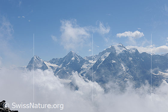 Foto: Wolkenstimmung um Dreigestirn Eiger, Mönch und Jungfrau. Die Hochalpengipfel ragen aus dem Wolkenmeer.