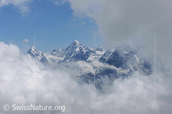 Foto: Stimmungsbild: Wolkenmeer in den Alpen. 
Durch eine Wolkenlücke sind Eiger und Mönch zu sehen.