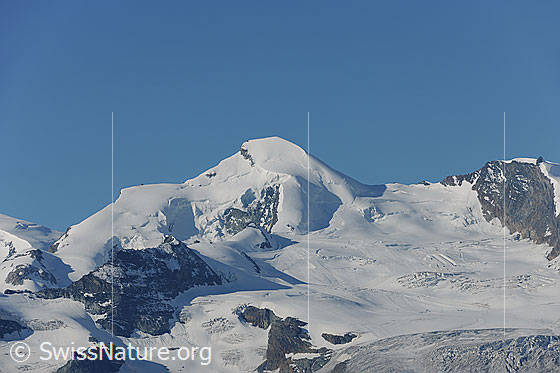 Foto: Allalinhorn und Feegletscher. 
Auf dem Gletscher ist ein Teil des Skigebiets von Saas Fee erkennbar.