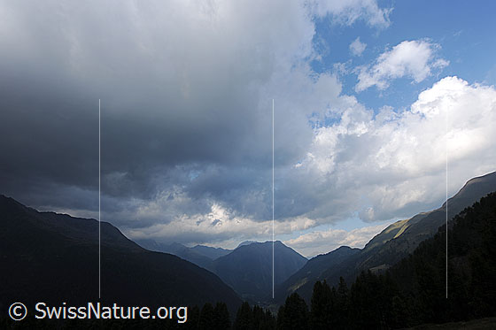 Foto: Bedrohliche Wolken während eines Föhnsturms kurz vor Föhnzusammenbruch. Dunkle Regenwolken dringen von Süden ins Binntal ein. Im Hintergrund ist das Breithorn zu sehen.