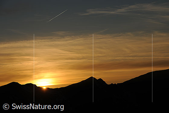 Foto: Abendstimmung über dem Diemtigtal mit Sonnenuntergang hinter der Silhouette einer Bergkette.