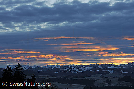 Foto: Morgenstimmung über der Emmentaler Hügellandschaft. In der Restbewölkung ist Morgenrot zu sehen.