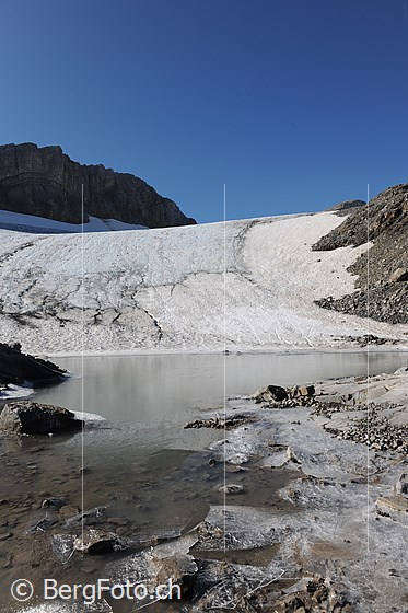 Foto: Eisreste am Ufer eines Gletschersees. Im Hintergrund mündet der Chilchligletscher in den See.