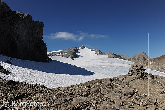 Foto: Chilchligletscher, Tungelgletscher und Wildhorn im Hintergrund. Davor ein Wegzeichen in der Form eines Steinmannes.