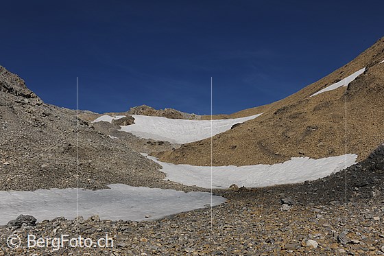 Foto: Schnidejoch von Süden (Wallis). Die karge Berglandschaft am Schnidejoch besteht aus Geröll und Schneefeldern.