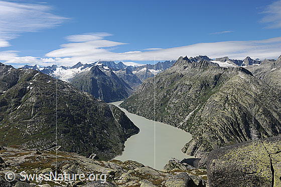 Foto: Berglandschaft um den Grimselsee (Stausee). Über den Berner Alpen sind Linsenwolken zu sehen.