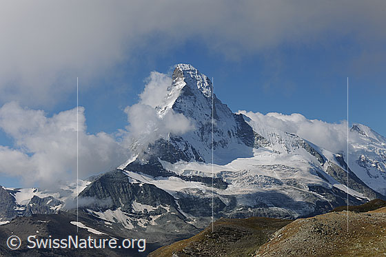 Foto: Das Matterhorn von Wolken umgeben.
Hörnligrat (links), Nordwand und Zmuttgrat (rechts). Davor der Matterhorngletscher.