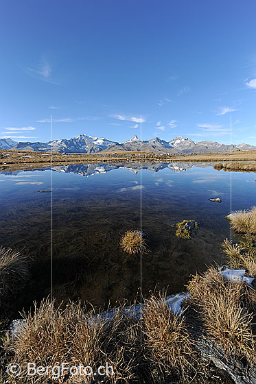 Foto: Spiegelung der Berner Alpen in Bergsee. Am Himmel sind ein paar Schleierwolken zu sehen.
