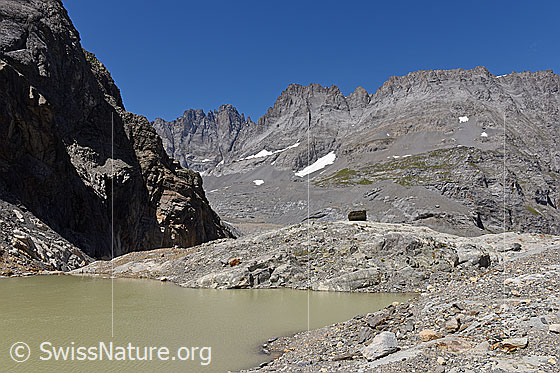 Foto: Blick über Gletschersee in karge Berglandschaft.