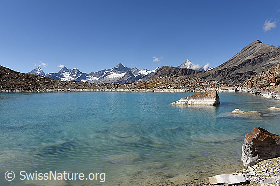 Foto: Blick über hellblauen Bergsee ins Hochgebirge.